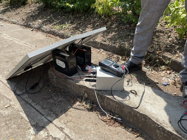 A photovoltaic panel, battery and measurement equipment set up outdoors during a field measurement